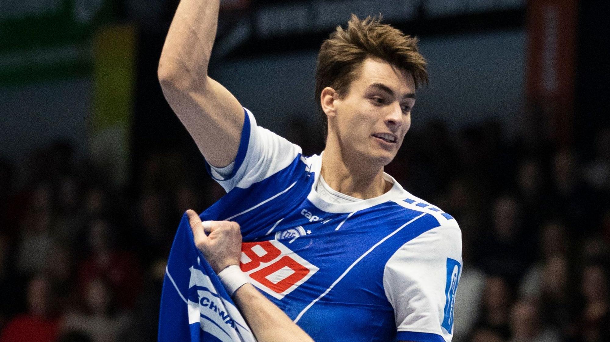 Handballer Julian Köster hebt mit dem Ball in der Hand zum Sprungwurf ab.