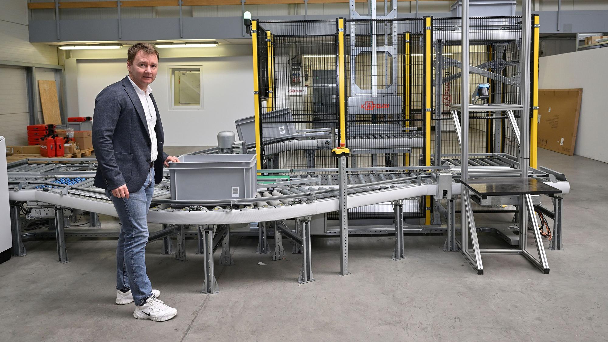 Firmenchef Oleksandr Klymenko führt das Modell einer automatischen Förderanlage am neuen Standort vor.