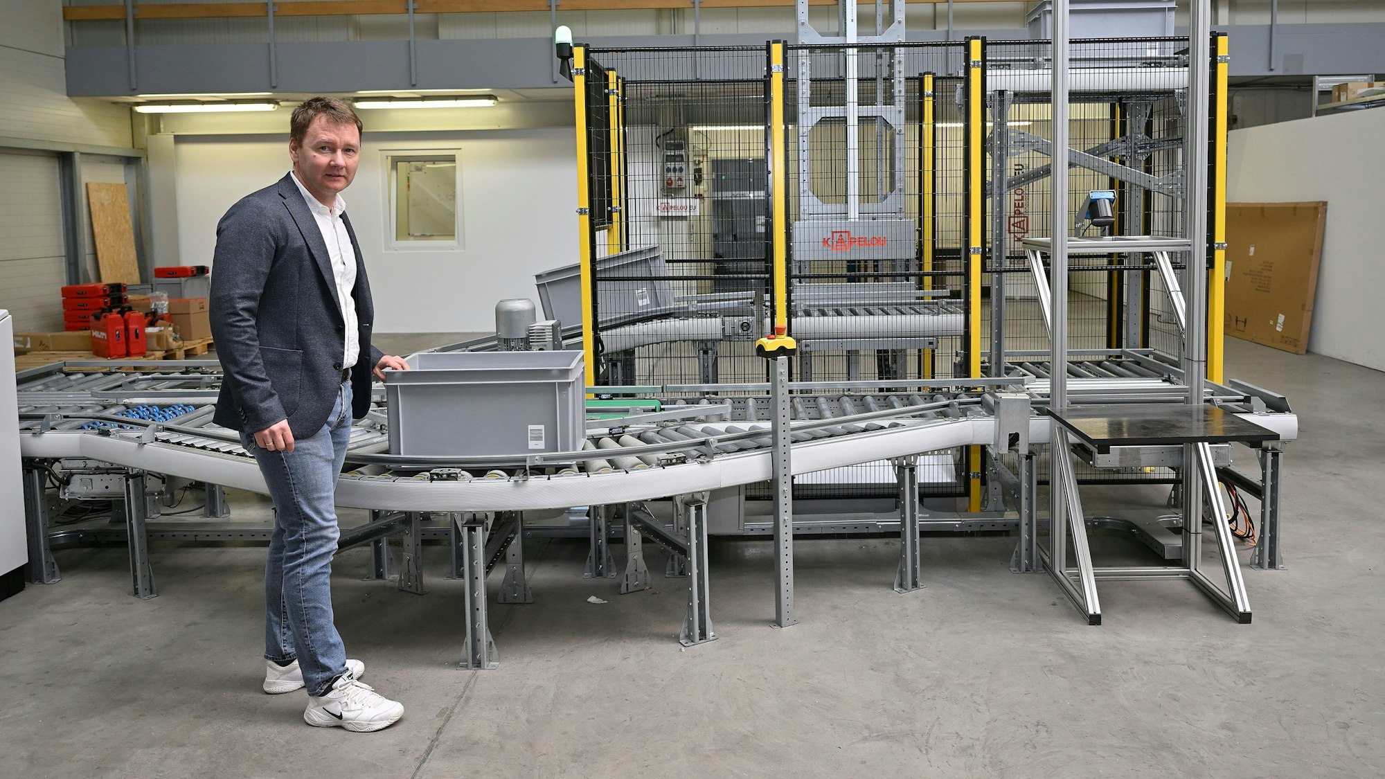 Firmenchef Oleksandr Klymenko führt das Modell einer automatischen Förderanlage am neuen Standort vor.