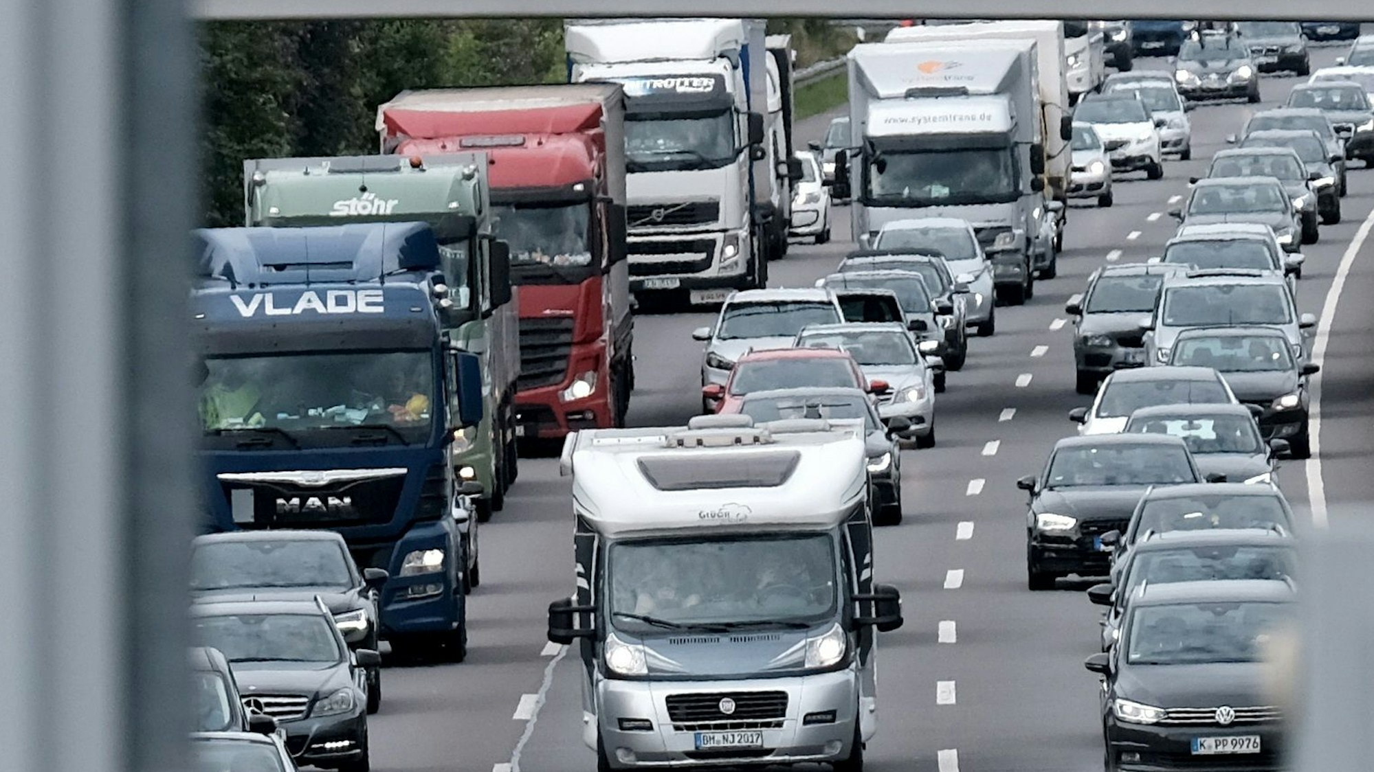 Dreispurig stehen LKW, Wohnmobile und PKW im Stau.