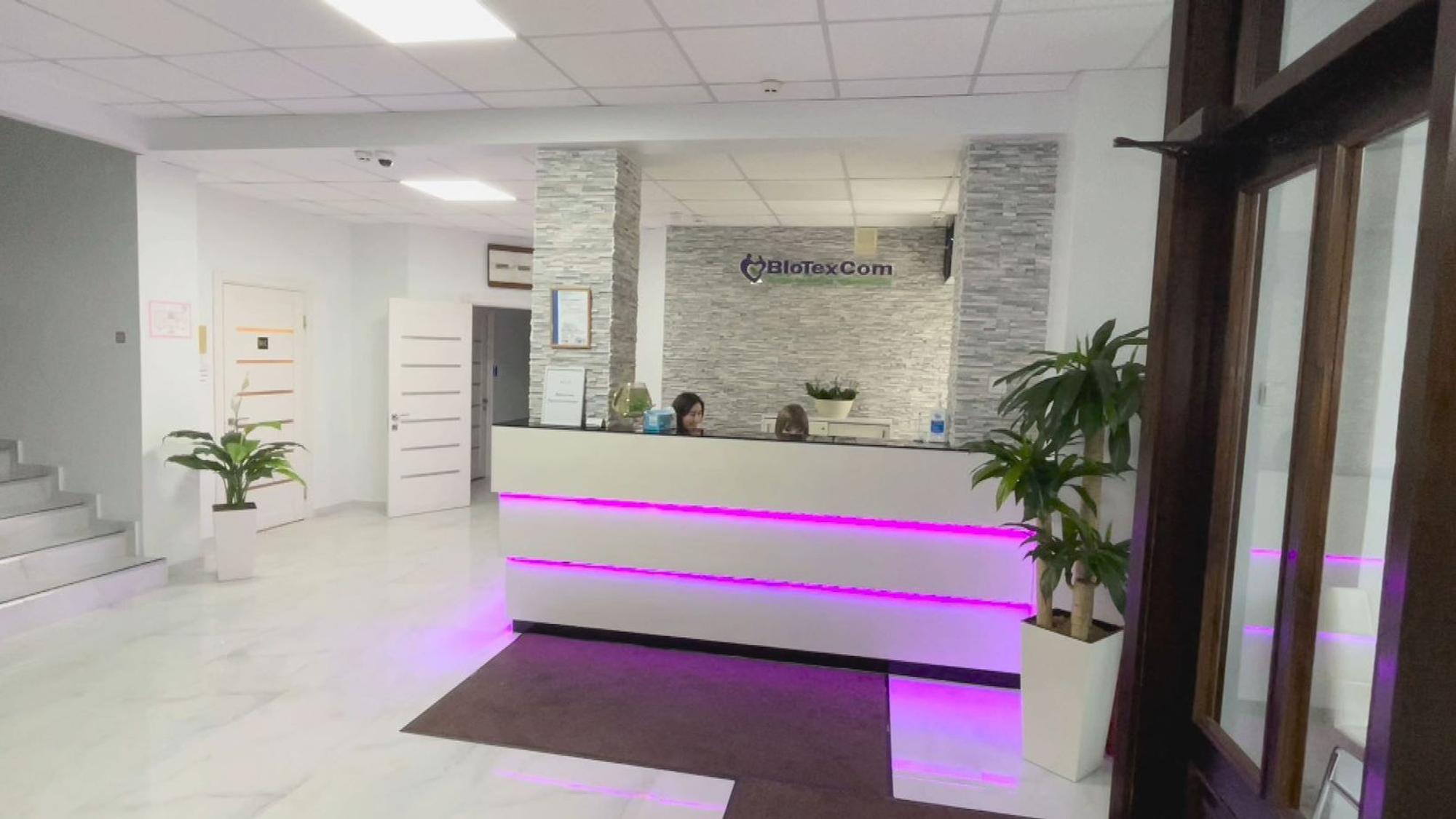 Zwei Mitarbeiterinnen sitzen hinter einem weißen Empfangstresen im Eingangsbereich der Biotexcom-Klinik in Kiew.