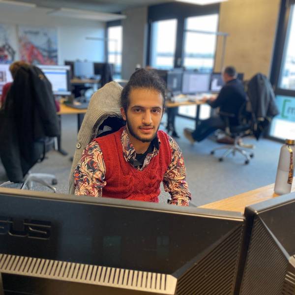 Der 21-jährige Mustapha Attar sitzt an einem der Arbeitsplätze in der Werbeagentur Lemm.