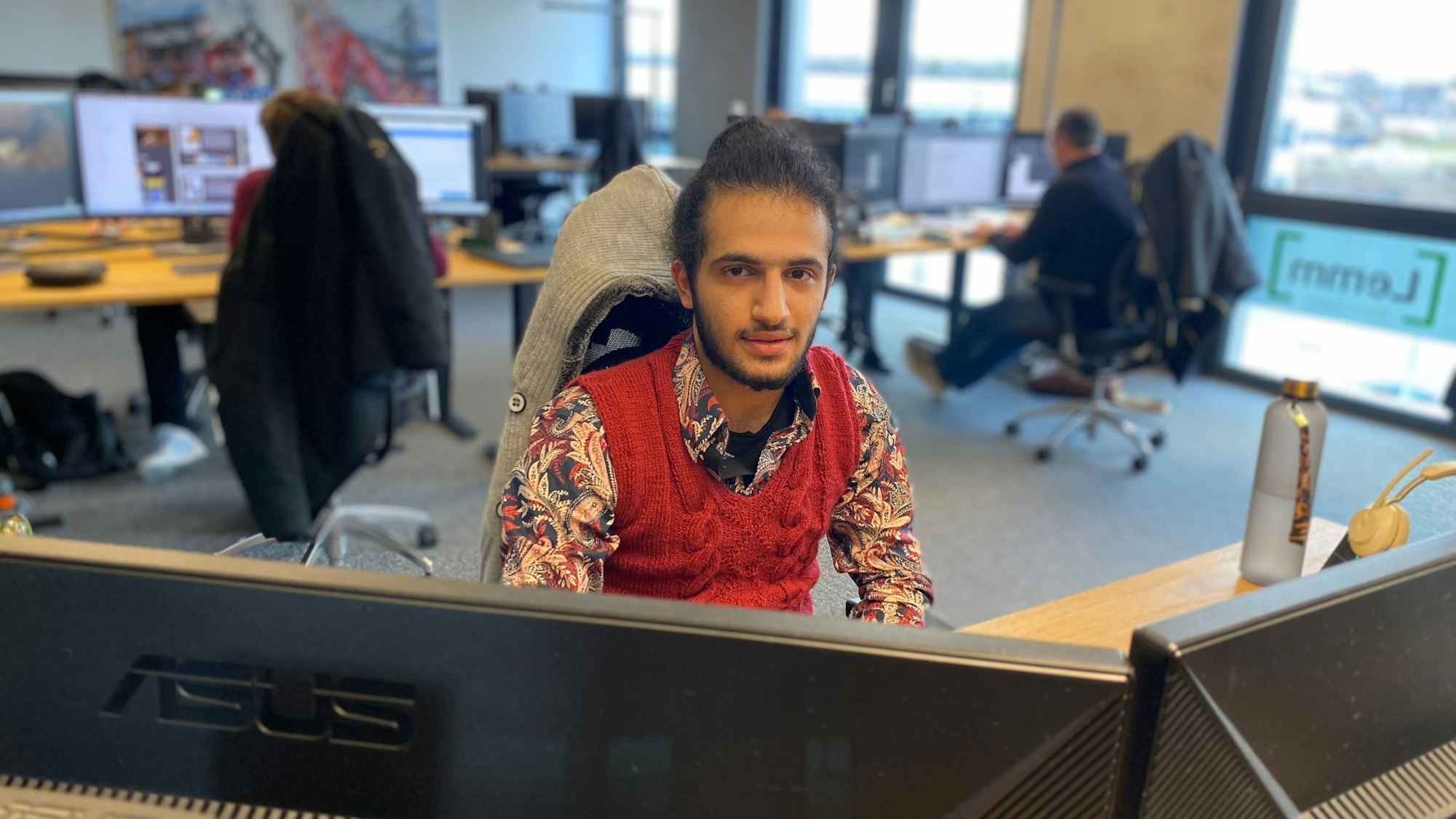 Der 21-jährige Mustapha Attar sitzt an einem der Arbeitsplätze in der Werbeagentur Lemm.