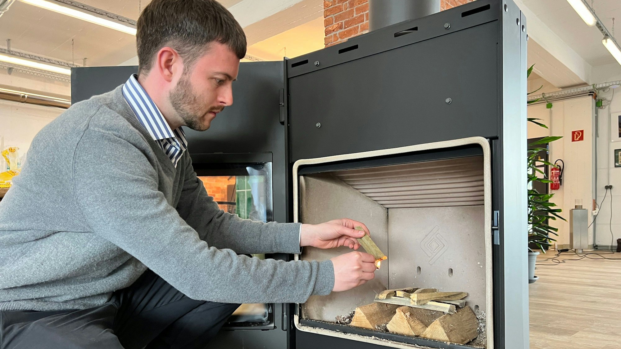 Robert Mülleneisen zündet ein Hölzchen an, um den Kamin anzufeuern