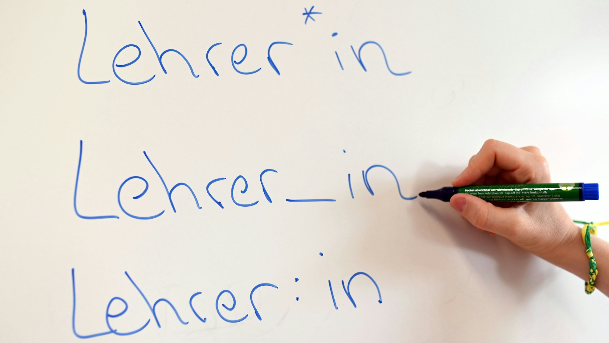 An einem Whiteboard steht das Wort "Lehrer" in verschiedenen Gender-Schreibweisen.