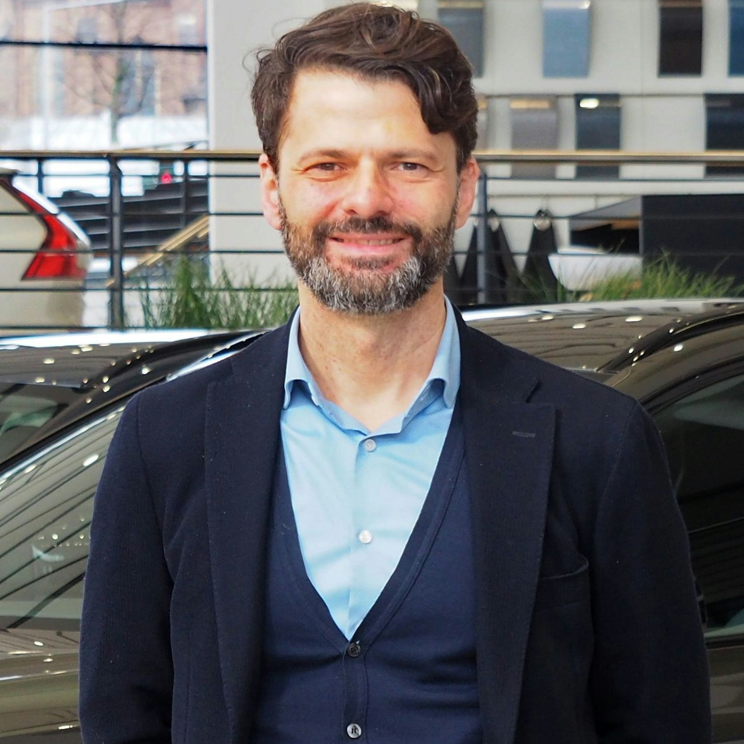 Der Geschäftsführer des Autohauses steht in seinem Laden.