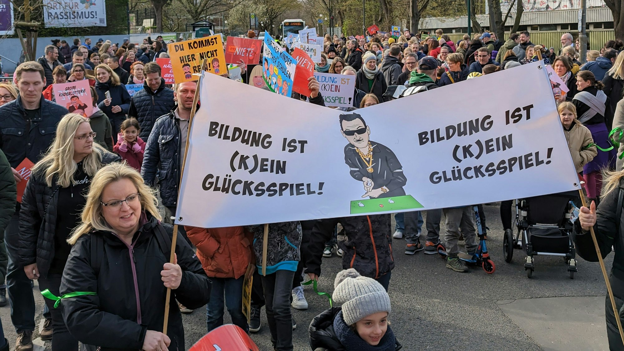Eltern und Kinder hatten dagegen protestiert, dass 31 Viertklässler nicht auf Hürther Gymnasien gehen sollten. Auf einem Transparent steht „Bildung ist (k)ein Glücksspiel!“.