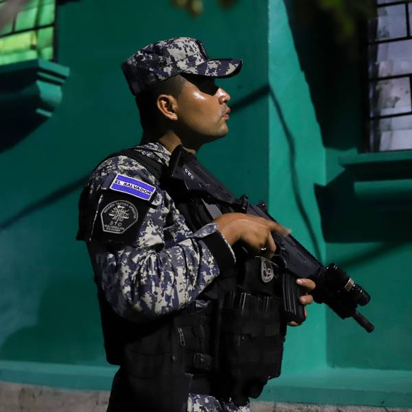 Ein Mitglied der nationalen Zivilpolizei von El Salvador hält in Tarnkleidung ein Gewehr.