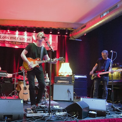Eine Band aus vier Männern steht auf einer Bühne.