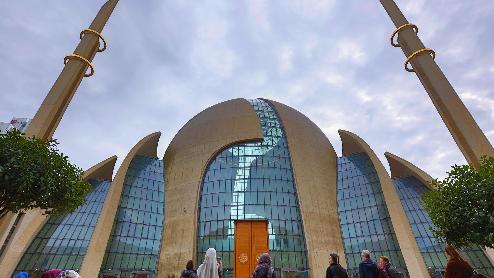Personen stehen vor der Zentralmoschee in Köln.