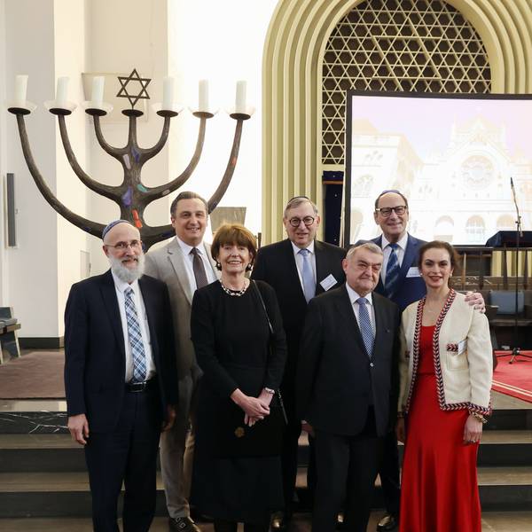 Verschiedene Funktionäre stehen in einer Synagoge