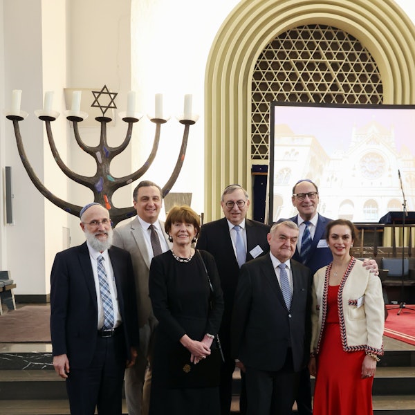 Verschiedene Funktionäre stehen in einer Synagoge