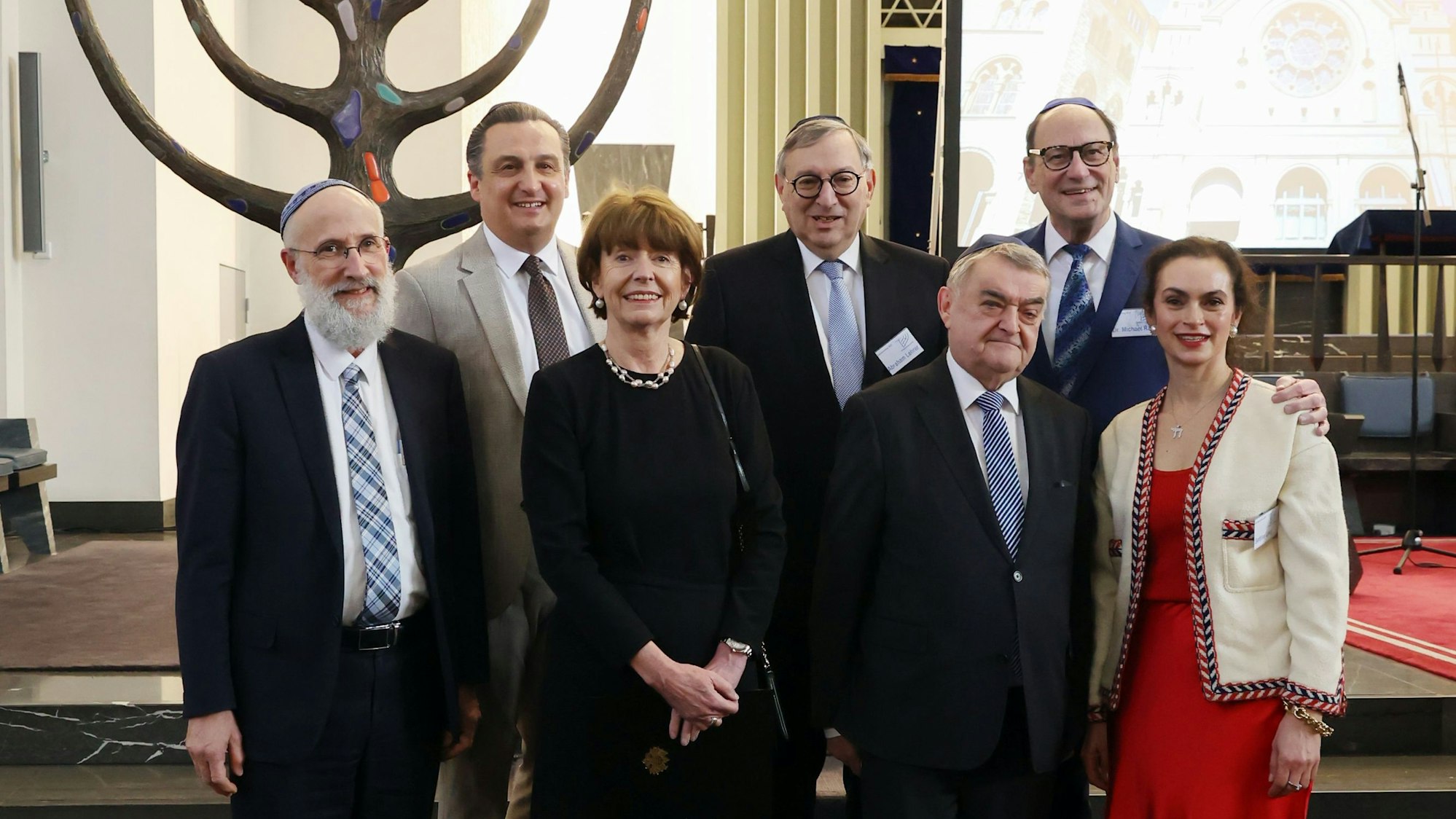 Verschiedene Funktionäre stehen in einer Synagoge
