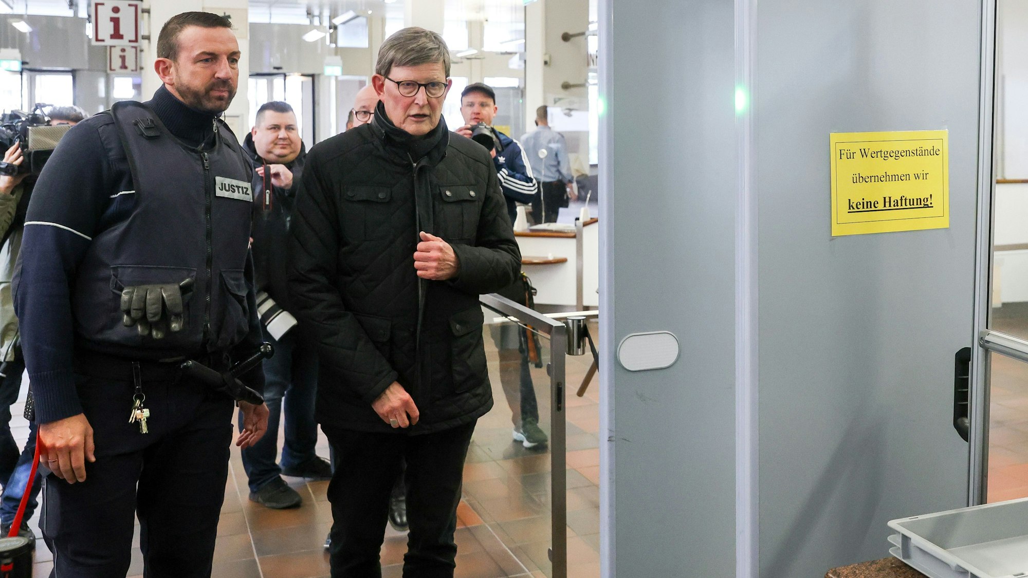 Kardinal Rainer Maria Woelki mit einem Wachtmeister beim Betreten des Kölner Landgerichts.