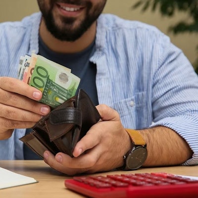 Mann zieht Euro Geldscheine aus der Geldbörse.