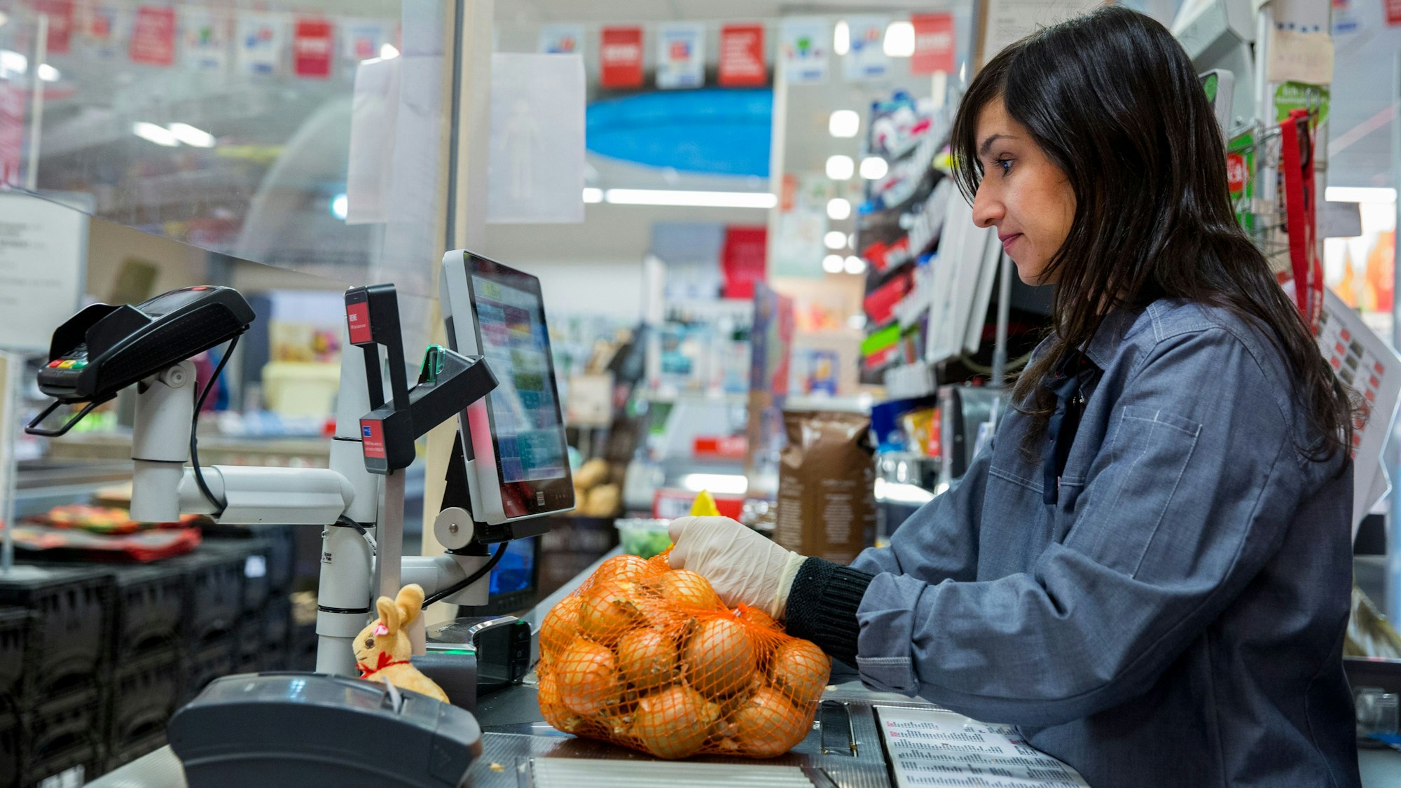 Eine Kassiererin registriert Zwiebeln an der Kasse.