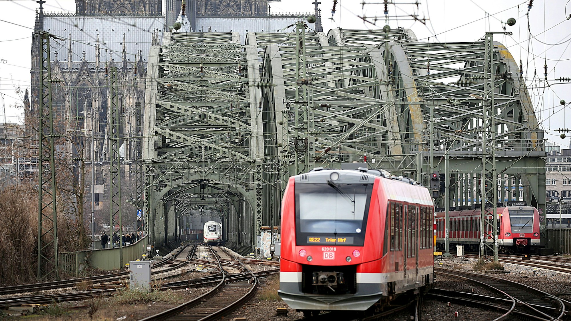 Eine Regionalbahn fährt über die Hohenzollernbrücke aus dem Kölner Hauptbahnhof aus. Im Hintergrund ist der Kölner Dom zu sehen. (Symbolbild)