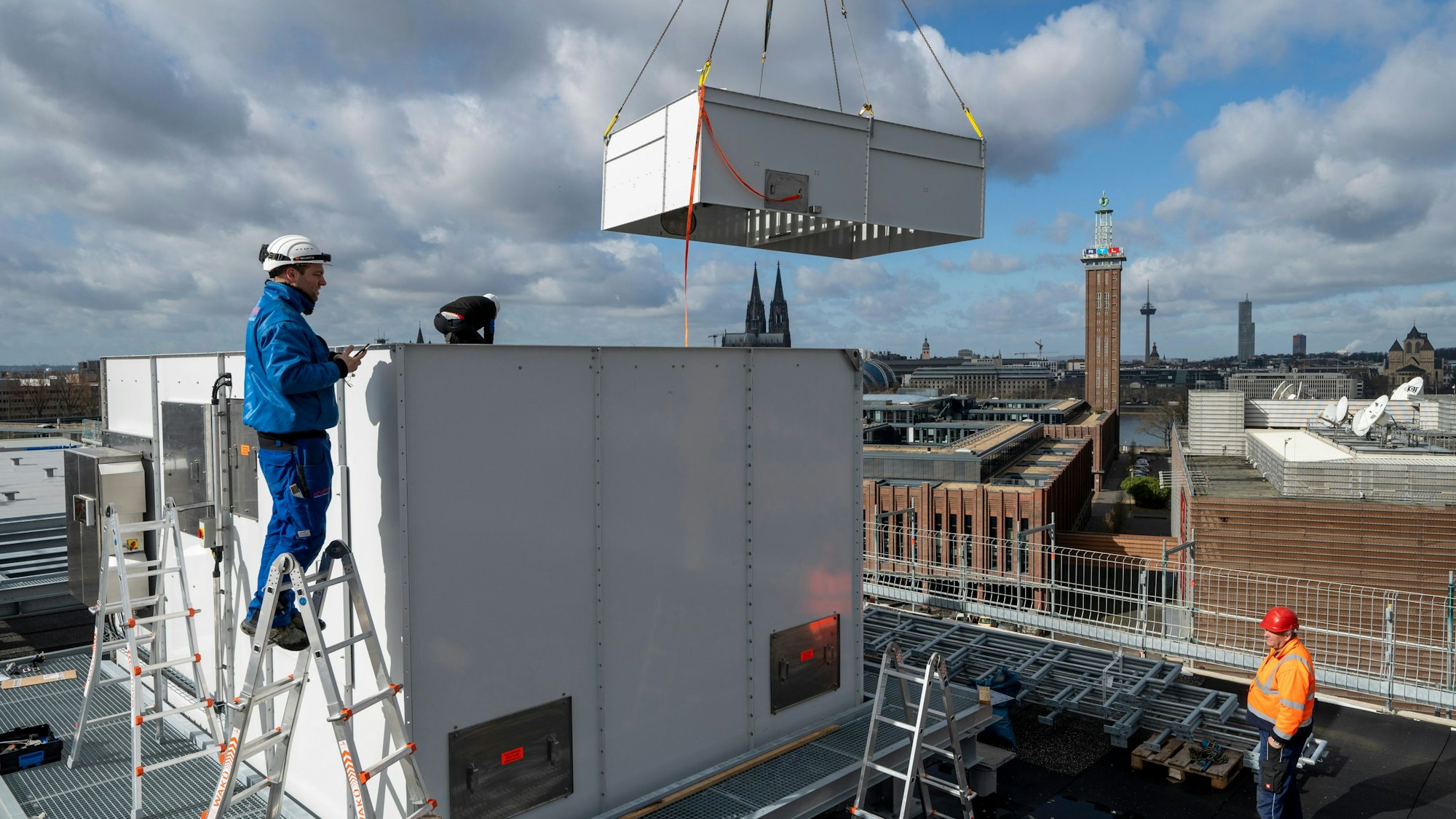 Kühltürme werden auf dem Dach des neuen Kongresszentrums montiert. Im Hintergrund sind Dom und Messeturm zu sehen.