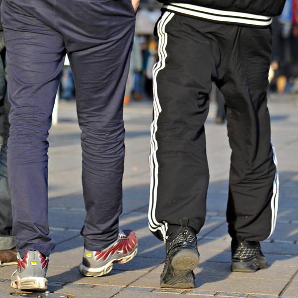 In Jogginghosen gehen junge Männer die Königstraße entlang.