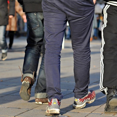 Schüler tragen Jogginghosen auf einem Schulhof.