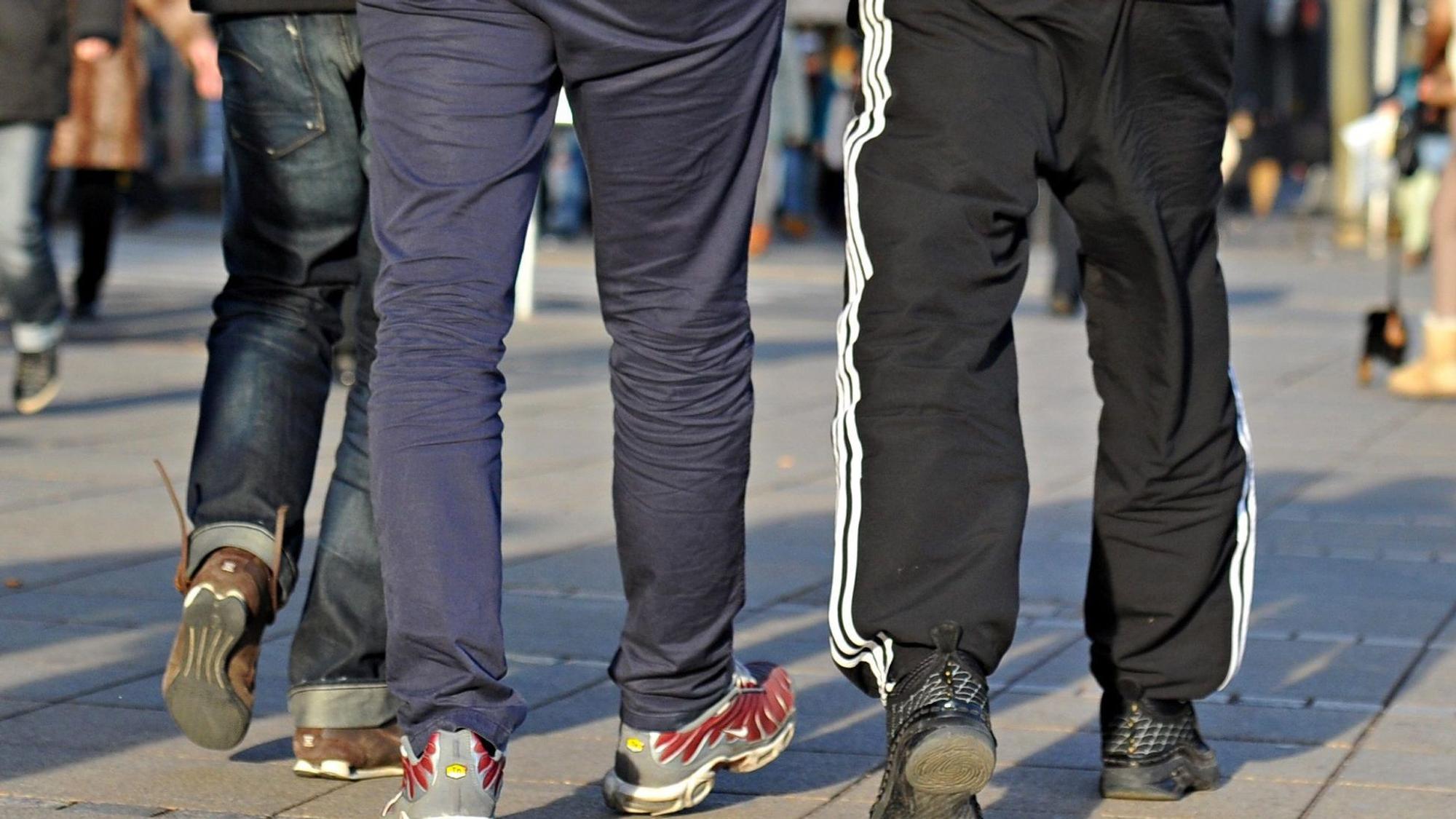 Baden-Württemberg, Stuttgart: In Jogginghosen gehen junge Männer die Königstraße entlang.