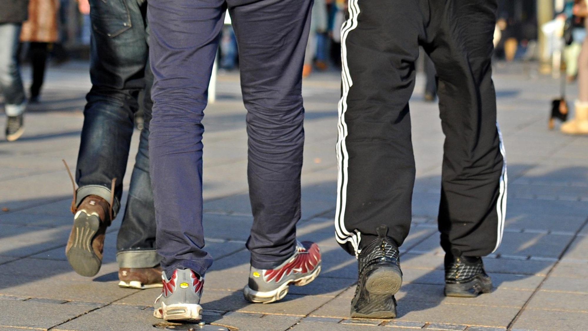 In Jogginghosen gehen junge Männer die Königstraße entlang. Ein Jogginghosen-Verbot an einer Schule in Wermelskirchen schlägt hohe Wellen. Medienberichten zufolge hat die Leitung der dortigen Sekundarschule begonnen, die schon länger geltende Kleiderordnung der Schule umzusetzen und Schüler in Jogginghosen nach Hause geschickt.