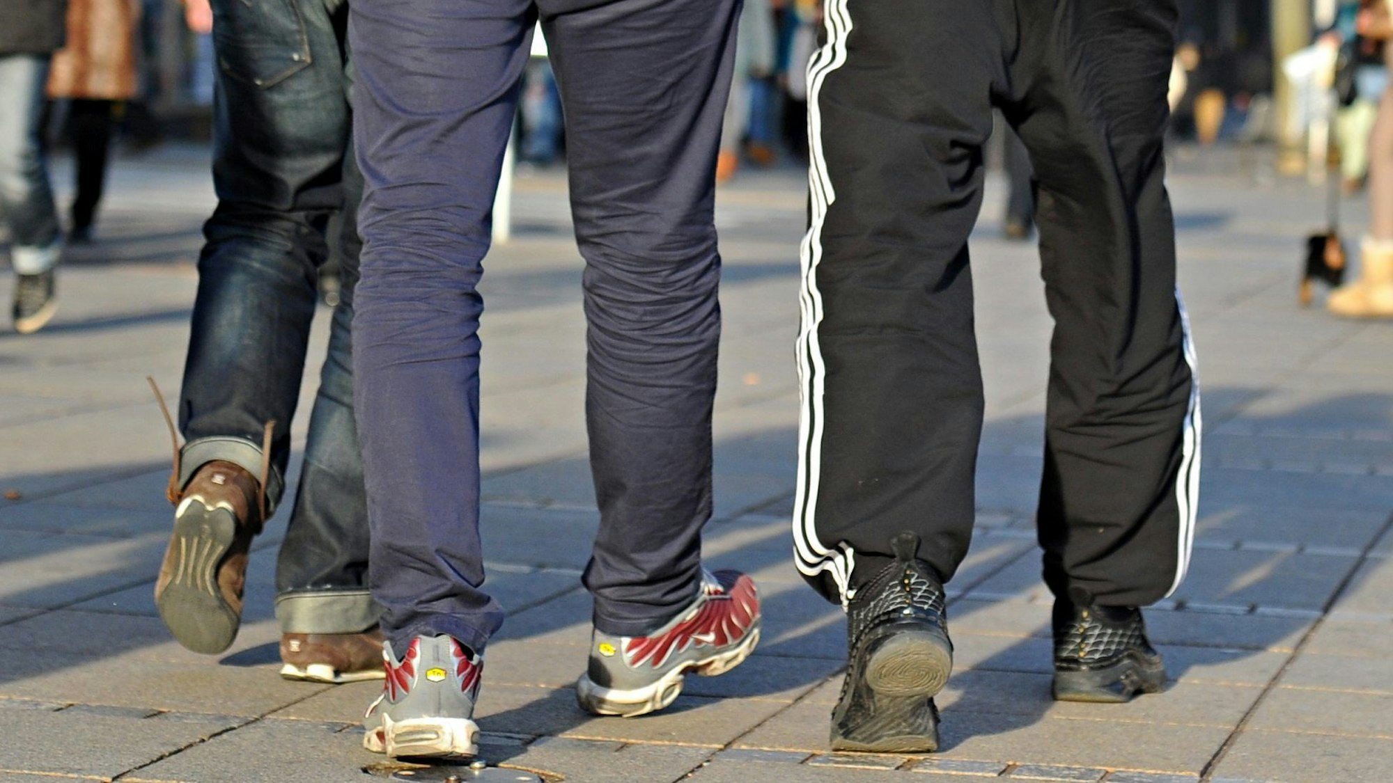 In Jogginghosen gehen junge Männer die Königstraße entlang. Ein Jogginghosen-Verbot an einer Schule in Wermelskirchen schlägt hohe Wellen. Medienberichten zufolge hat die Leitung der dortigen Sekundarschule begonnen, die schon länger geltende Kleiderordnung der Schule umzusetzen und Schüler in Jogginghosen nach Hause geschickt.