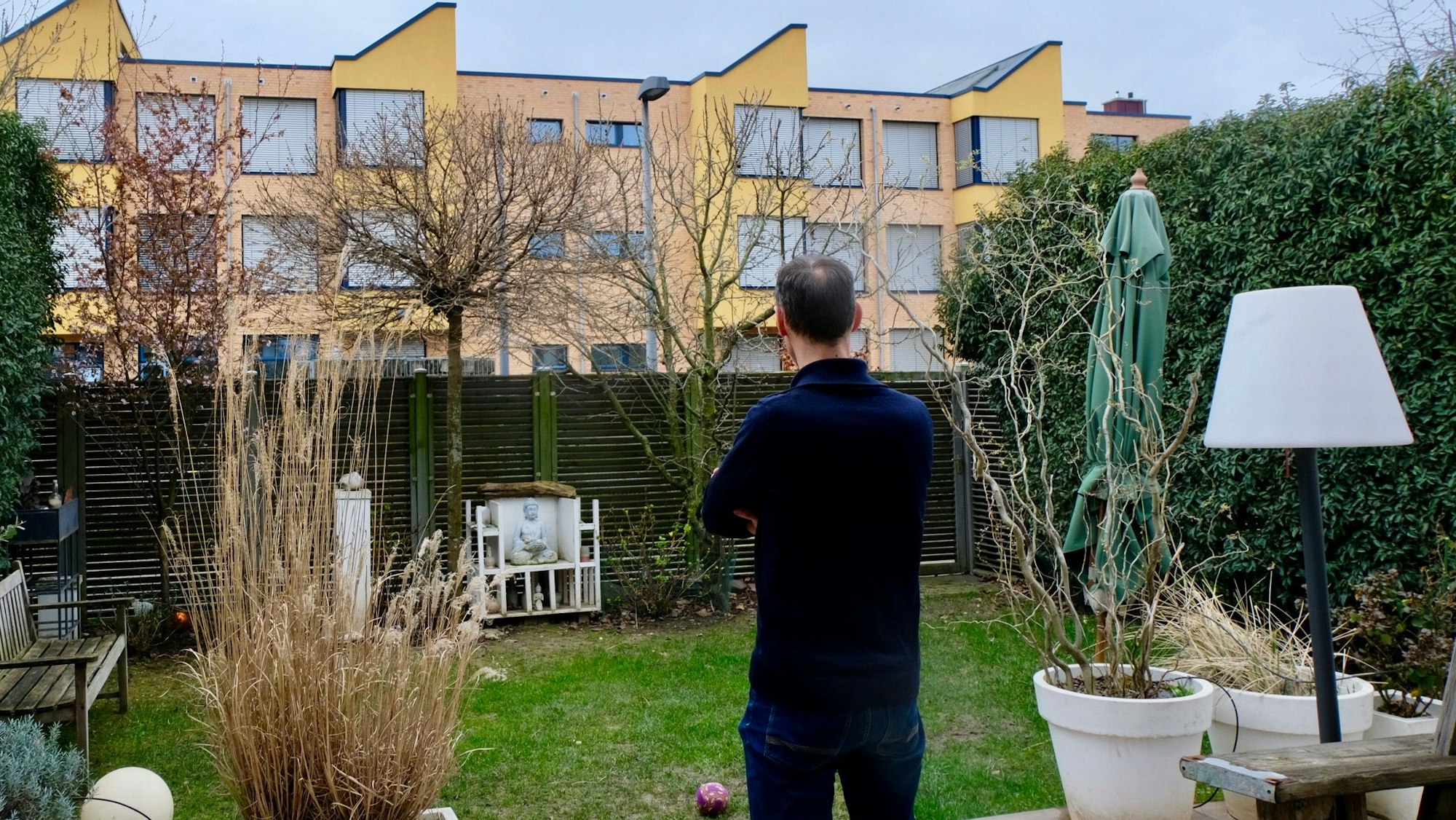 Anwohner, der von seinem Garten aus auf ein Schulgebäude blickt