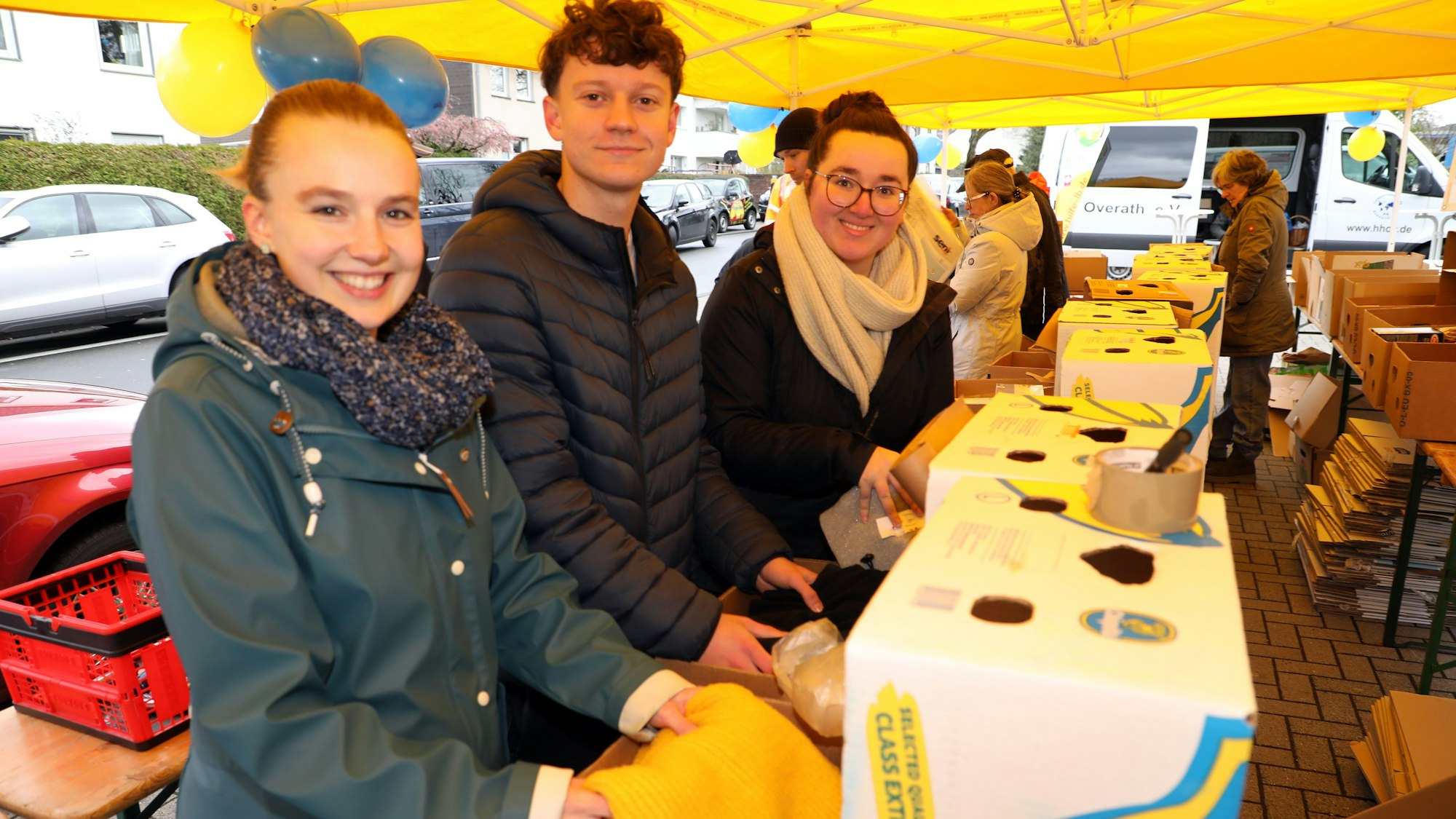 Jugendreferentin Lea Gietz (l.) hilft mit Firmlingen und Katecheten beim Bananenkistenpacken