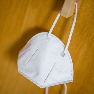 Eine FFP2-Maske hängt an einem Haken.