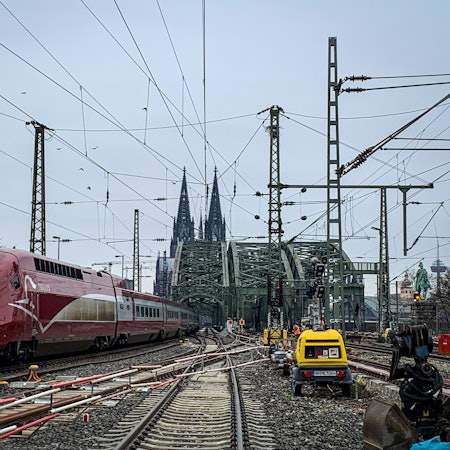 28.11.2022, Bauarbeiten an den Weichen im Bahnhof Köln Messe/Deutz sind zu sehen. Im Hintergrund der Dom und links im Bild ein roter Thalys-Zug.