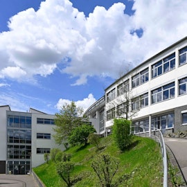 Eine Außenansicht des Berufskollegs Oberberg an einem wolkigen, aber sonnigen Tag.