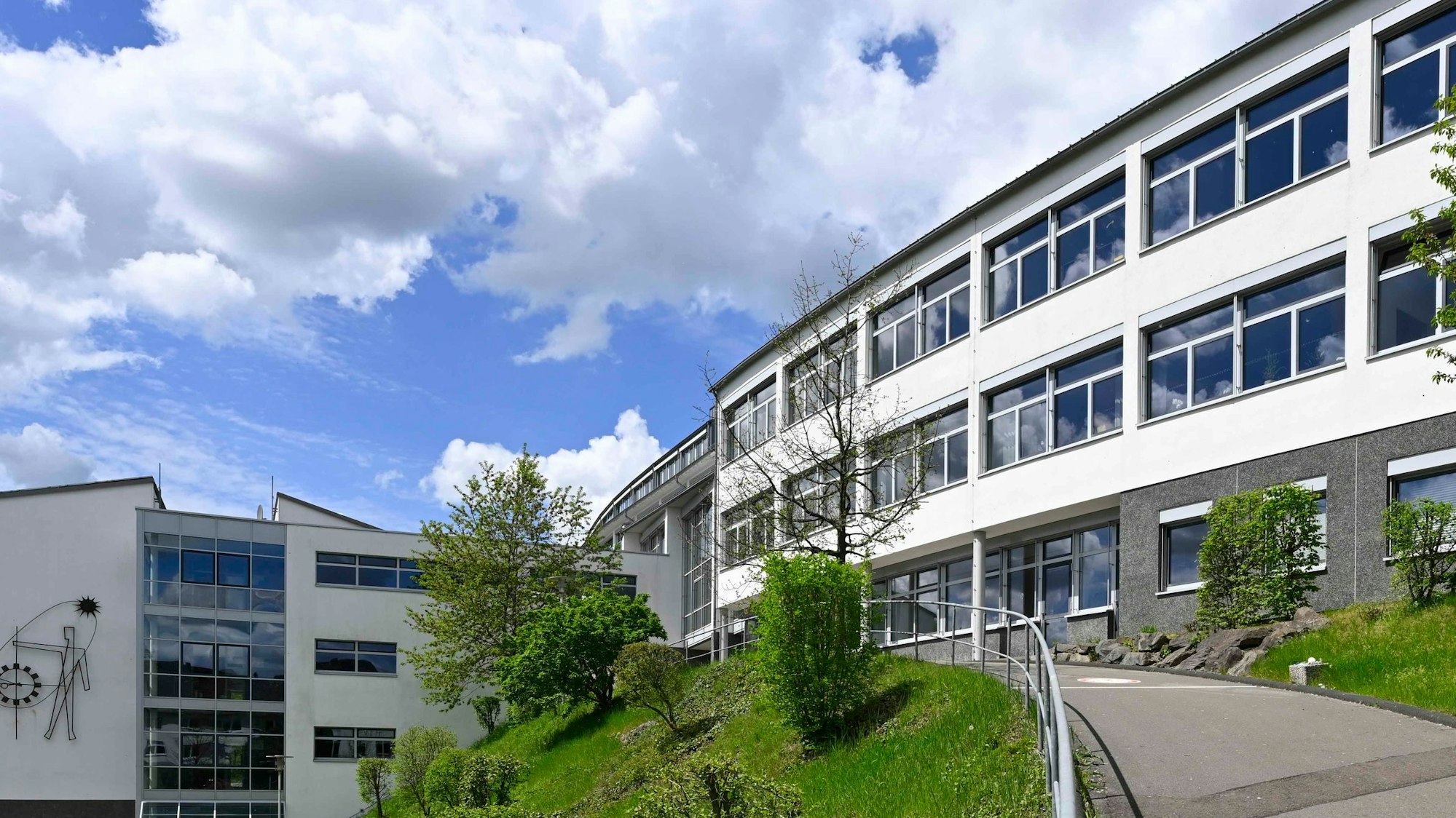 Eine Außenansicht des Berufskollegs Oberberg an einem wolkigen, aber sonnigen Tag.