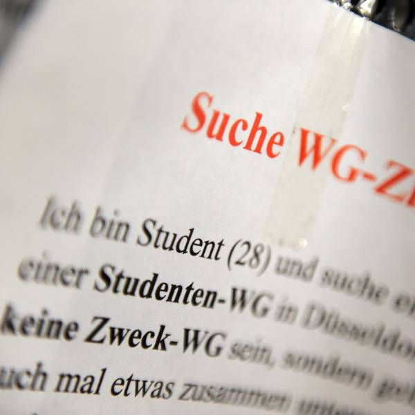 Ein Zettel mit der Aufschrift „Suche WG-Zimmer“ hängt an einem Schwarzen Brett.