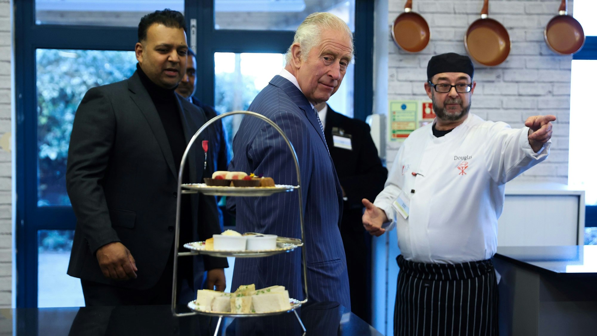 König Charles III. (M) bei einem Besuch der Londoner Gemeinschaftsküche, um Studenten und Freiwillige zu treffen und die Einrichtungen zu besichtigen. Unter anderem besuchte er den Markt für überschüssige Lebensmittel, die Kochschule und das «Kind Cafe». +++ dpa-Bildfunk +++