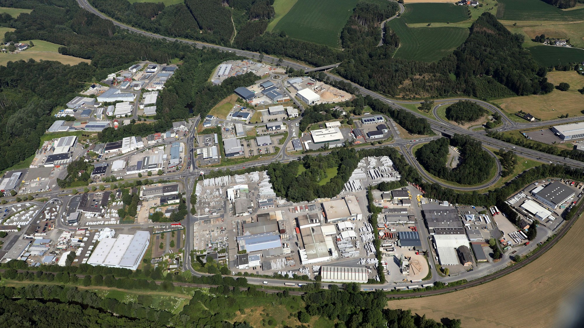 Auf einer Luftaufnahme stehen im Gewerbegebiet viele Gebäude nebeneinander.