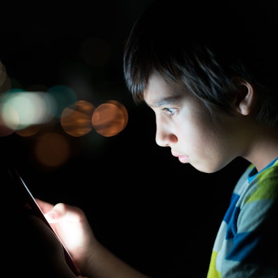 Kind schaut erschrocken auf ein Handy