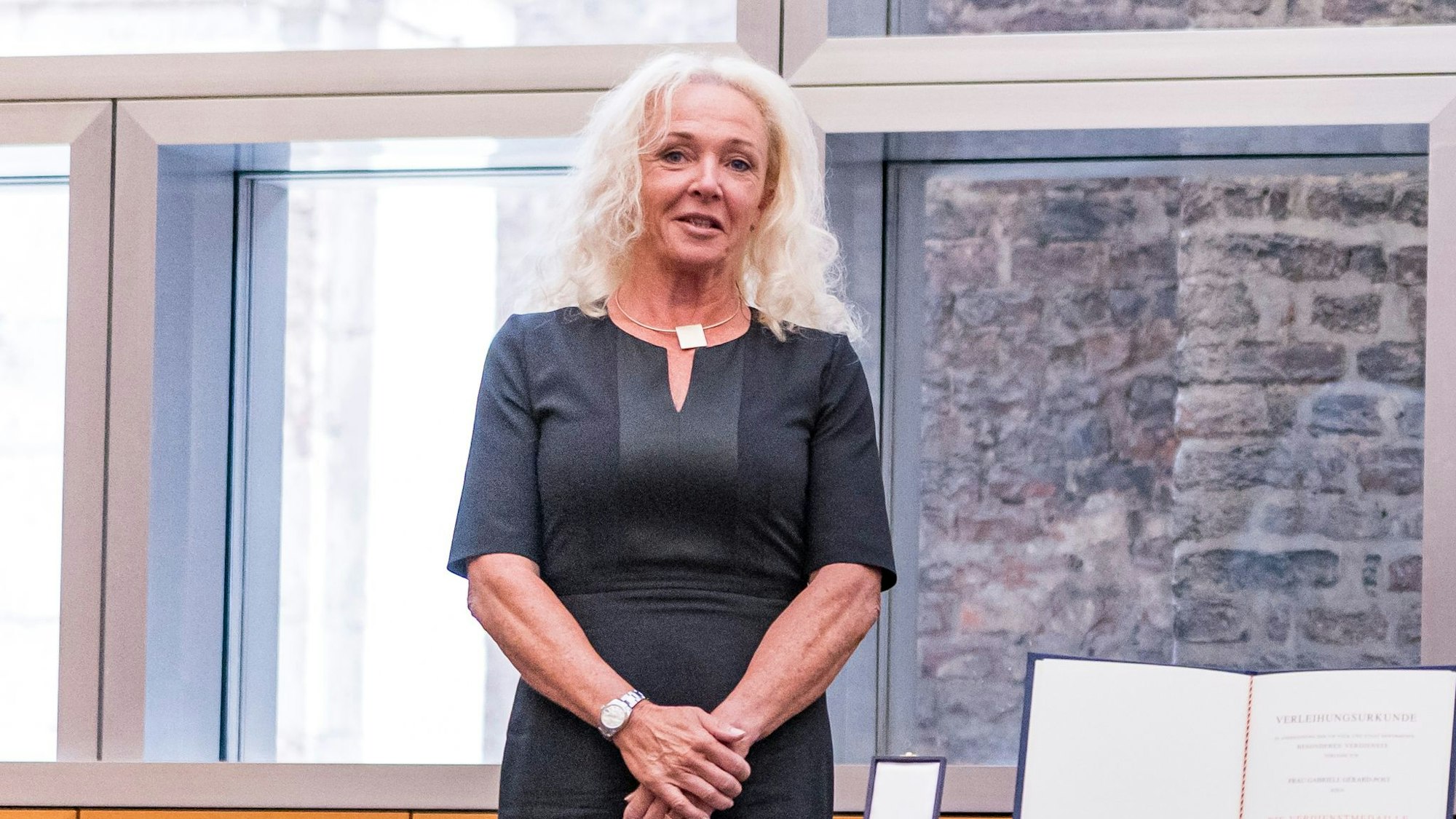 Gabriele Gérard-Post schaut in die Kamera. Auf dem Porträt trägt sie ein schwarzes Kleid.