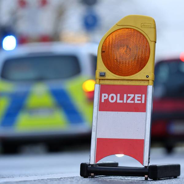 Eine Polizei-Warnbake steht auf einer Kölner Straße. Autos fahren im Hintergrund. (Symbolbild)