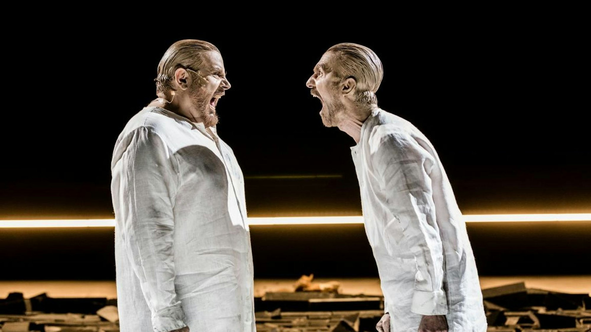 „Das große Heft/Der Beweis/Die dritte Lüge“ am Schauspiel Köln: Bruno Cathomas (l.) und Seán McDonagh stehen in weißen Hemden auf der Bühne und schreien einander an
