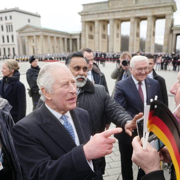 König Charles III. von Großbritannien am Brandenburger Tor mit Bundespräsident Frank-Walter Steinmeier. Ihm gegenüber steht ein Mann mit einer Krone der Fast-Food-Kette „Burger King“.