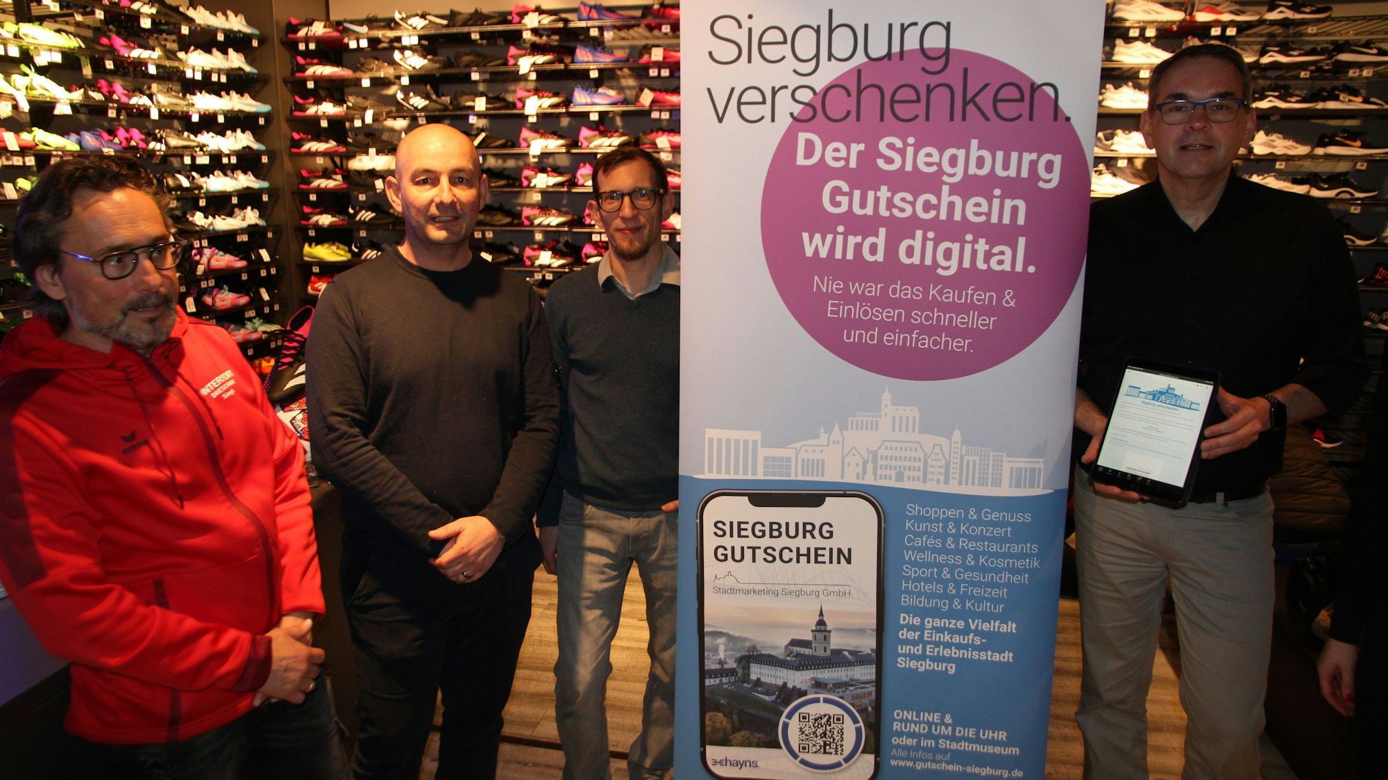 Der digitale Siegburg-Gutschein wird bei Intersport Dreschmann in der Holzgasse vorgestellt, von links: Guido Dreschmann, Sissis Vassiliadis, Ole Erdmann und Stefan Rosemann