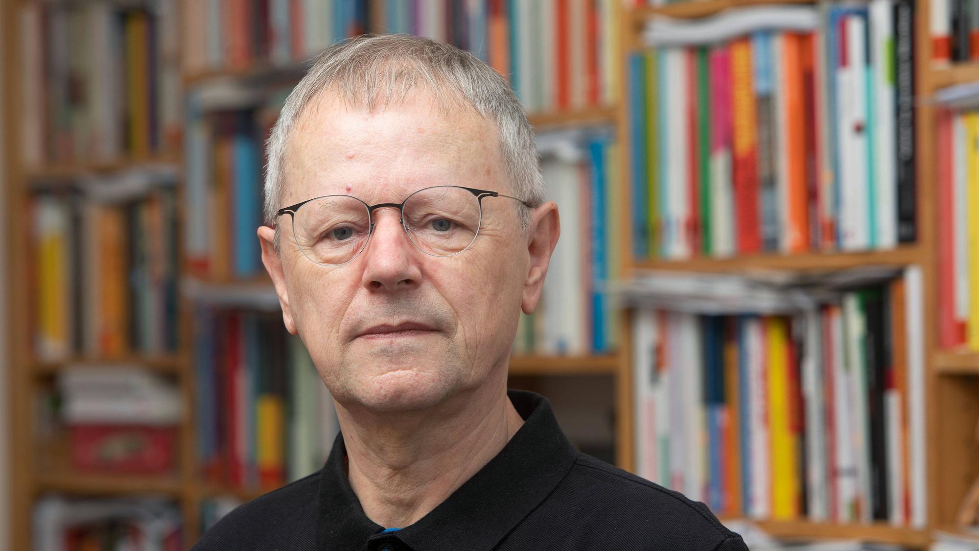 Das Foto zeigt Cristoph Butterwegge vor einem Bücherregal.