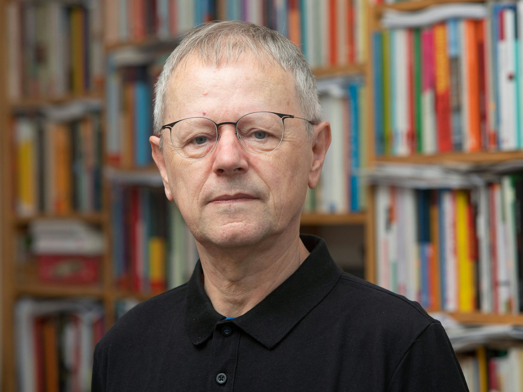 Christoph Butterwegge im Porträt vor einer Bücherwand