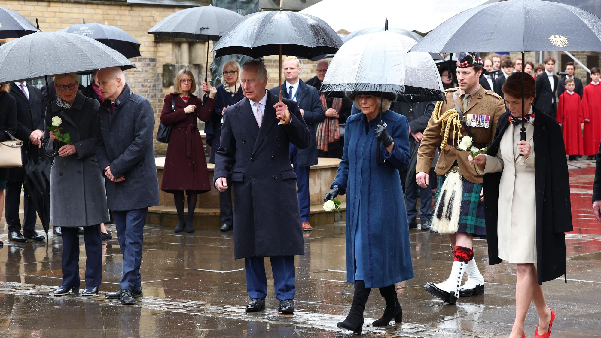Das Königspaar Charles und Camilla (m.) mit Begleiter Johnny Thompson (Hintergrund, rechts)