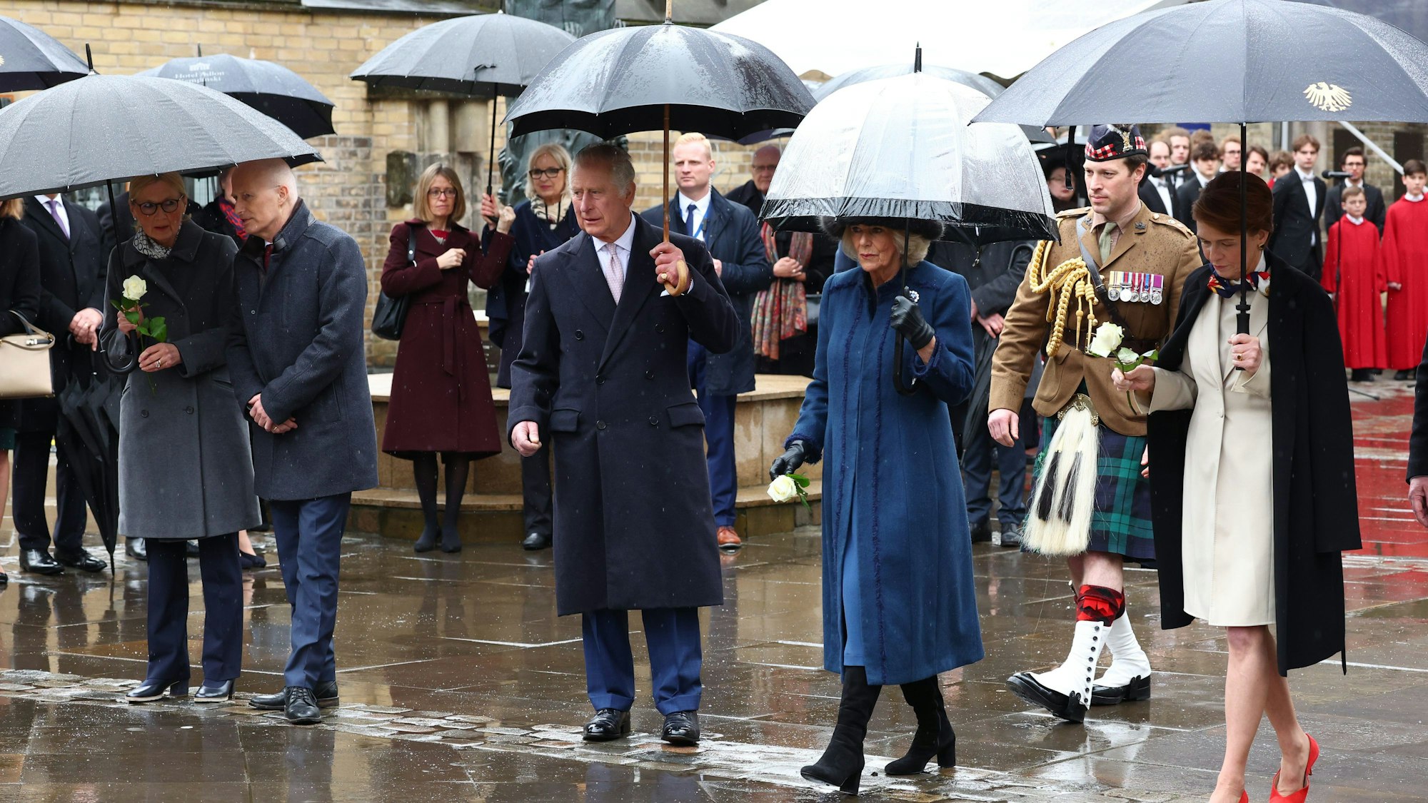 Das Königspaar Charles und Camilla (m.) mit Begleiter Johnny Thompson (Hintergrund, rechts)