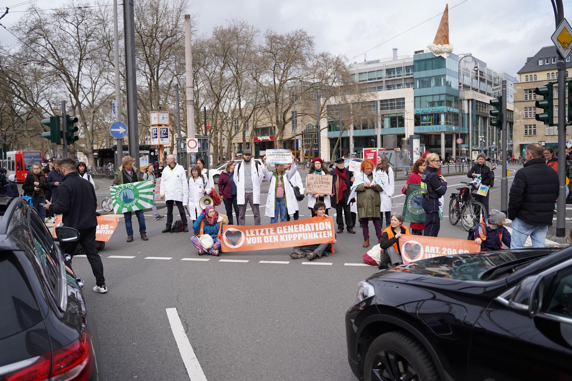 Klimaaktivisten am Neumarkt blockieren den Straßenverkehr.