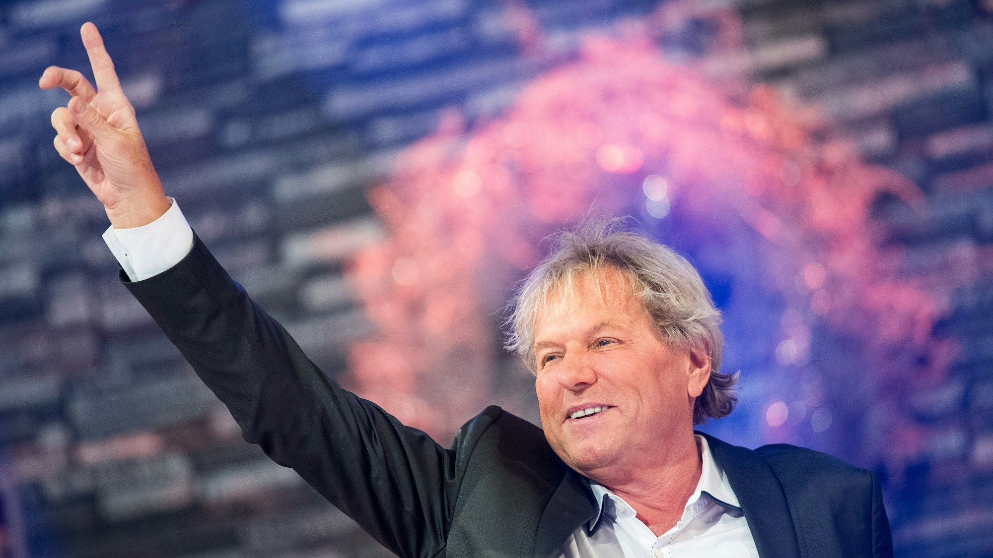 Bernhard Brink streckt bei einem Auftritt den Arm nach oben.