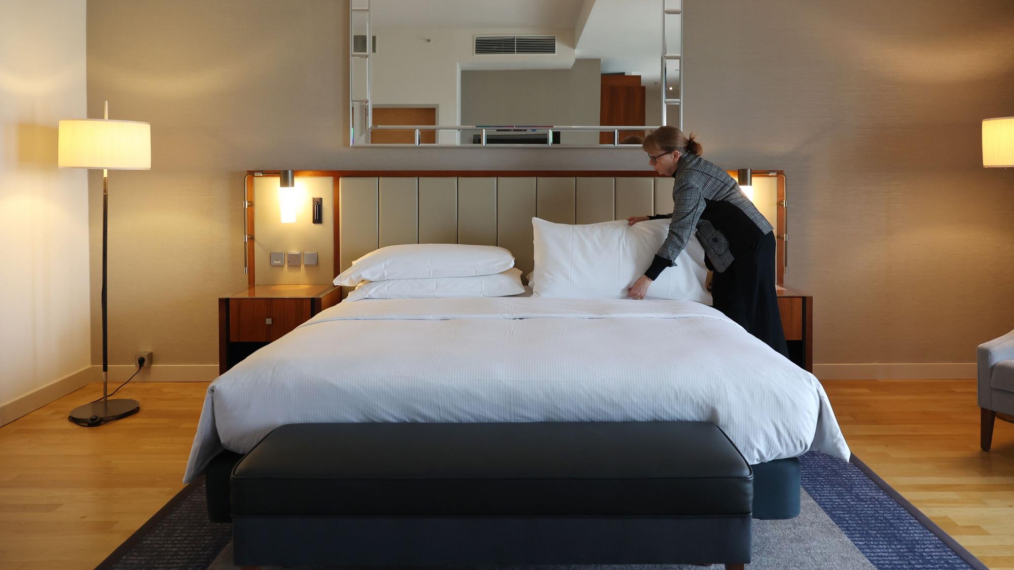 Hausdame Andrea Pilz überprüft ein Bett im Hotelzimmer.