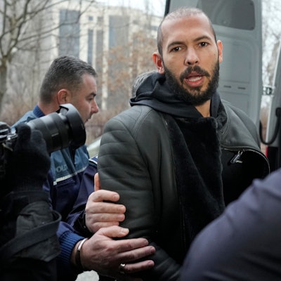 Polizeibeamte eskortieren Andrew Tate.